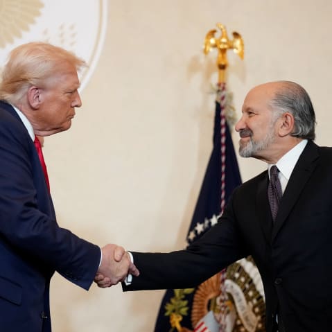 President Donald Trump shakes hands with Secretary of Commerce Howard Lutnick in Tokyo, Japan.