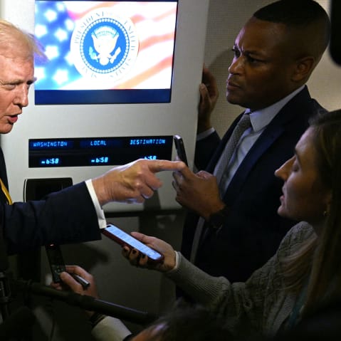 U.S. President Donald Trump speaks to reporters aboard Air Force One.