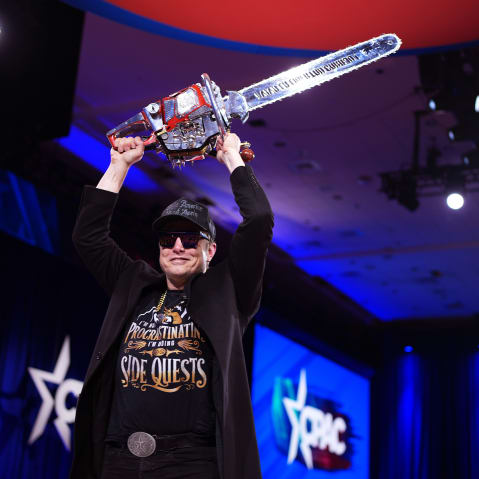 Elon Musk leaves the stage holding a chainsaw after speaking at the Conservative Political Action Conference in Oxon Hill, M.D., on Feb. 20, 2025.