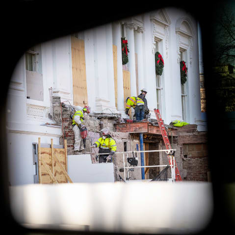 Construction workers take down material where the East Wing used to connect to the White House on Dec. 1.