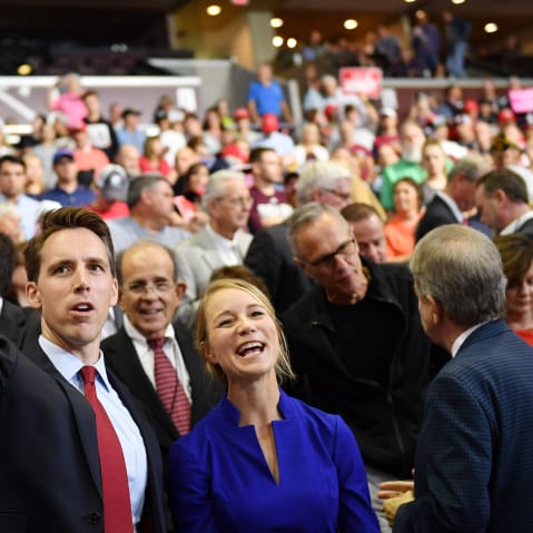 Then Missouri Attorney General Josh Hawley, left, and his wife Erin Morrow Hawley wave at a rally in Springfield, MO