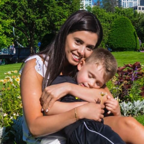Bruna Ferreira and hugging her young son in a park