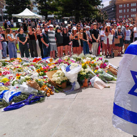 People gather at a memorial outside the Bondi Pavilion to mourn those killed in a mass shooting attack in Sydney.