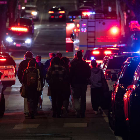 Emergency personnel escort students from one of the buildings of Brown University in Providence, Rhode Island, on Dec.13, 2025.
