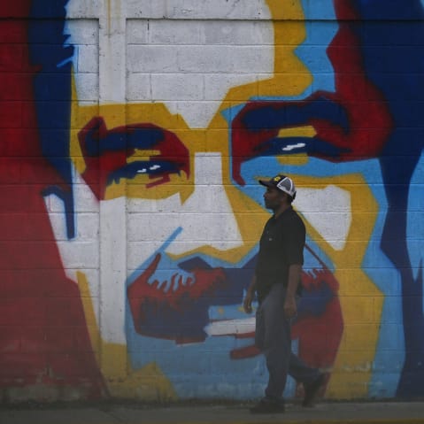 A man walks past a graffiti depicting Venezuelan President Nicolas Maduro in Caracas on January 3, 2026.