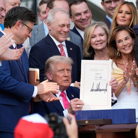 Congressional Republicans and Melania Trump surround President Donald Trump as he signs the "One, Big Beautiful Bill" Act.