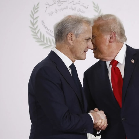 Jonas Gahr Store, left, is shaking Donald Trump's hand with Trump's face behind Store's.