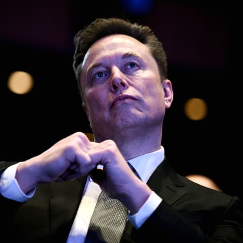 Elon Musk looking up at the stage while President Trump speaks.