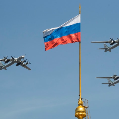FILE - Russian Tu-95 strategic bombers fly past a Russian flag at the Kremlin complex during a rehearsal for the Victory Day military parade in Moscow, Russia, May 4, 2018. (AP Photo/Pavel Golovkin, File)