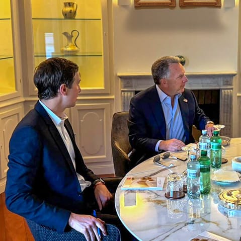 Jared Kushner, Steve Witkoff and Badr Albusaidi sit around a table as they talk.