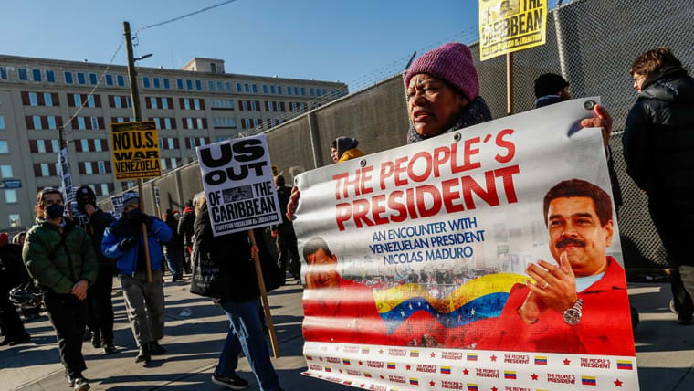 Protester holds poster featuring Nicolas Maduro which reads, in part, "The People's President."