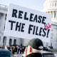 A protester holds a sign related to the release of the Jeffrey Epstein case files outside the Capitol.