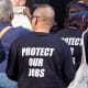 Protesters wearing "Protect our Jobs" t-shirts.