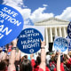 People hold signs saying "Safe Abortion is a Human Right" and "Keep abortion legal"