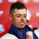Rory McIlroy sits in front of a microphone.