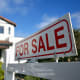 A for sale sign is displayed outside of a home.