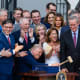 President Donald Trump holds a gavel as Republican lawmakers applaud.