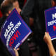 A person holds a sign that reads "Mass Deportation Now" during the third day of the Republican National Convention.