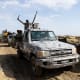 A Multinational Joint Task Force (MNJTF) military escort accompanying an excavator digging trenches passes through a checkpoint in Borno state, Nigeria.