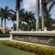 A sign is seen near the entrance to the Trump National Doral golf resort, many palm trees in the background near resort buildings
