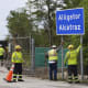 Workers install a sign reading "Alligator Alcatraz" at the entrance to a new migrant detention facility at Dade-Collier Training and Transition facility, Thursday, July 3, 2025, in Ochopee, Fla.