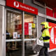 Image: A postman enters an Australia Post store