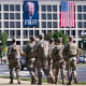 National Guard soldiers patrol on Aug. 26, 2025, in front of a banner of President Donald Trump on the Department of Labor in Washington.