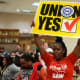 A woman holds a sign that says "Union Yes"