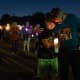 People hold candles at a vigil.