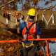 A worker removes the words "Trump Place" from a residential building in New York in 2016.