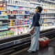 A person looks at products in the dairy aisle of a supermarket