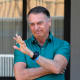 Former Brazilian President Jair Bolsonaro waves at his residence in Brasilia on Sept. 11, 2025.