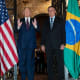 Donald Trump speaks with Jair Bolsonaro standing next to him