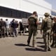 Manufacturing plant employees waiting to have their legs shackled at the Hyundai Motor Group’s electric vehicle plant on Sept. 4, 2025, in Ellabell, Ga.