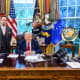 Economist E.J. Antoni stands next to President Donald Trump at his desk in the Oval Office