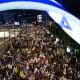 Demonstrators lift placards and flags during a protest in Tel Aviv, Israel.