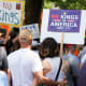 Activists carry signs during a "No Kings" protests.