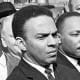 A federal marshal reads a court order halting a planned voter registration protest as Dr. Martin Luther King Jr., right, and fellow marcher Andrew Young, left, look on.