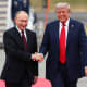 Donald Trump and Vladimir Putin shaking hands.
