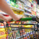 A woman pushes a shopping cart to choose products in a supermarket.
