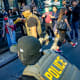A Federal agent pulls out his taser as law enforcement conduct a raid on street vendors during rush hour. New Yorkers are seen witnessing the attempted detainments began protesting and attempted to block agents.