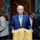 Mitch McConnell stands next to his chair.