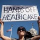 Brenda Patoine holds a sign that reads "Hands off Healthcare"