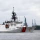 A Coast Guard ship sails past the Statue of Liberty.