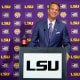 Lane Kiffin stands behind a podium at a press conference at Tiger Stadium in Baton Rouge, L.A.