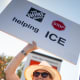 A woman holds a sign that reads "Home Depot Stop Helping ICE" at an anti-ICE and Home Depot protest; Rachel Maddow.