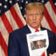 Then former U.S. President Donald Trump holds up a news story about New York Attorney General Letitia James as he speaks to the media at one of his properties at 40 Wall Street following closing arguments at his civil fraud trial on Jan. 11, 2024, in New York City.