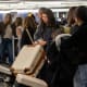 Travelers pick up luggage at a baggage carousel at San Francisco International Airport.