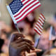 Ali Velshi; Naturalized citizens participate in the Oath Ceremony, waving American flags.