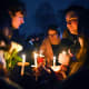 People hold candles during a vigil for those injured and killed during the Saturday shooting at Brown University.